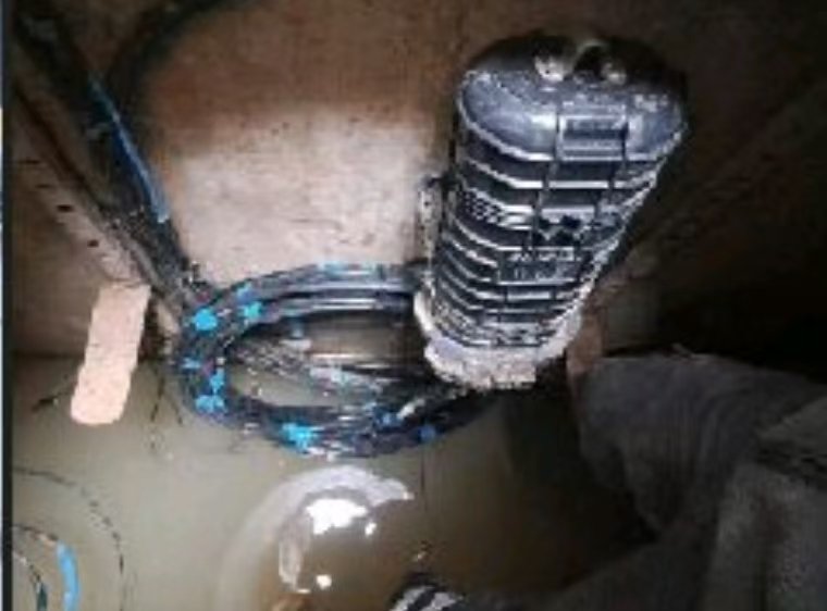 IP68 waterproof fiber optic splice closure submerged in a manhole for underground FTTX networks.